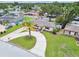 A single-story home with a circular driveway and a vibrant palm tree, surrounded by lush green landscaping at 5934 51St N Ave, Kenneth City, FL 33709