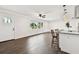 Open concept living space with hardwood floors, white walls, ceiling fan, and bright windows at 5934 51St N Ave, Kenneth City, FL 33709