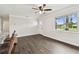 Open concept living space with hardwood floors, white walls, ceiling fan, and bright windows at 5934 51St N Ave, Kenneth City, FL 33709