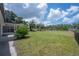 Expansive backyard featuring green grass, palm trees, and a canal view, offering a serene outdoor space at 6108 Oak Ridge Ave, New Port Richey, FL 34653