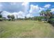 Expansive waterfront backyard showcasing a well-maintained lawn, mature palm trees, and picturesque water views at 6108 Oak Ridge Ave, New Port Richey, FL 34653