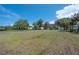 Large backyard with lush grass, a carport, and a view of the two-story home, great for outdoor enjoyment at 6108 Oak Ridge Ave, New Port Richey, FL 34653
