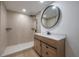 Modern bathroom featuring a sleek vanity, tiled shower, contemporary fixtures, and round mirror at 6108 Oak Ridge Ave, New Port Richey, FL 34653