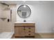 Modern bathroom featuring a sleek vanity with a round mirror, tiled shower, and contemporary fixtures at 6108 Oak Ridge Ave, New Port Richey, FL 34653