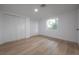 Bright bedroom featuring hardwood floors, neutral walls, and large windows for ample natural light and closet at 6108 Oak Ridge Ave, New Port Richey, FL 34653