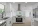 Open kitchen layout with stainless steel appliances, sleek vent hood, and quartz countertops at 6108 Oak Ridge Ave, New Port Richey, FL 34653