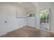 Bright laundry area with white cabinets, wood-look floors, and access to the outdoor deck at 6108 Oak Ridge Ave, New Port Richey, FL 34653