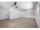Bright, open living room with light hardwood floors and two modern ceiling fans at 6108 Oak Ridge Ave, New Port Richey, FL 34653