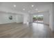 Bright and airy living room featuring updated flooring and sliding glass doors to a wooden deck at 6108 Oak Ridge Ave, New Port Richey, FL 34653
