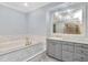 Luxurious bathroom featuring a soaking tub with marble surround and elegant vanity with chandelier lighting at 6220 Bayshore Blvd, Tampa, FL 33611