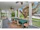 Covered patio with ceiling fans, dining table, and beautiful view of mature trees at 6220 Bayshore Blvd, Tampa, FL 33611