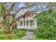 Inviting two-story home with covered porches surrounded by lush landscaping and majestic live oak trees at 6220 Bayshore Blvd, Tampa, FL 33611