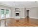 A living room featuring a fireplace, wood floors, ceiling fan, and doors to the outside at 6220 Bayshore Blvd, Tampa, FL 33611