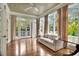 A living room with neutral decor, wood floors, many windows with curtains and access to a porch at 6220 Bayshore Blvd, Tampa, FL 33611