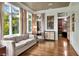 A living room with neutral decor, wood floors, many windows with curtains and an open door to the office at 6220 Bayshore Blvd, Tampa, FL 33611