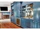 A living room with a blue custom bar with a wine fridge and fireplace at 6220 Bayshore Blvd, Tampa, FL 33611