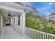 A white porch with columns offers serene views of lush landscaping at 6220 Bayshore Blvd, Tampa, FL 33611