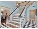 Elegant staircase with dark wood and white banisters, and black and white checkerboard tile at 6220 Bayshore Blvd, Tampa, FL 33611