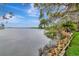 Picturesque waterfront view with lush trees bordering calm water, set under a beautiful blue and cloudy sky at 6220 Bayshore Blvd, Tampa, FL 33611