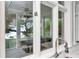 A window view to the covered outdoor living space with ceiling fan, outdoor seating and mature trees at 6220 Bayshore Blvd, Tampa, FL 33611