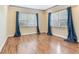 Bedroom featuring hardwood flooring, neutral paint, and windows with blinds and blue curtains at 6360 1St N St # 202, St Petersburg, FL 33702