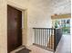 Condominium entryway with brown door, black iron railing and stairs leading down at 6360 1St N St # 202, St Petersburg, FL 33702