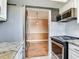 Galley kitchen showcasing stainless steel appliances, white cabinets, and view into the dining area at 6360 1St N St # 202, St Petersburg, FL 33702