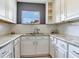 Close-up of kitchen featuring granite countertops, white cabinets, subway tile backsplash and stainless steel sink at 6360 1St N St # 202, St Petersburg, FL 33702