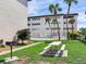Community pool and grilling area, surrounded by landscaping with lush green grass and palm trees at 6360 1St N St # 202, St Petersburg, FL 33702