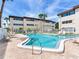 Community pool with lounge chairs surrounded by lush landscaping and condo buildings at 6360 1St N St # 202, St Petersburg, FL 33702