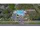Aerial view of the community amenities: a pool, clubhouse, parking lot, and playground surrounded by trees and greenery at 6909 Holly Heath Dr, Riverview, FL 33578