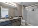 Bathroom featuring a double vanity with granite counters and glass-enclosed shower at 6909 Holly Heath Dr, Riverview, FL 33578