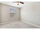 Neutral-toned bedroom featuring carpeted floors, a ceiling fan, and a window allowing natural light at 6909 Holly Heath Dr, Riverview, FL 33578