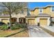 Traditional two-story townhome with attached garages, landscaped yard, and mature shade trees at 6909 Holly Heath Dr, Riverview, FL 33578