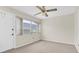 Bright bedroom featuring a ceiling fan, large window, and neutral carpet at 7000 Lafayette N, Pinellas Park, FL 33781