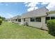 Back exterior of a single story home featuring a tidy lawn and neutral exterior at 7000 Lafayette N, Pinellas Park, FL 33781