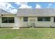 Side exterior view showing the back door to the single story house with a tidy lawn at 7000 Lafayette N, Pinellas Park, FL 33781
