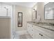 Elegant bathroom with double vanity, granite countertops, decorative mirrors, and walk-in shower at 702 W Kentucky Ave, Tampa, FL 33603