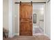 Stylish bathroom entry featuring a modern barn door, leading to a well-appointed vanity at 702 W Kentucky Ave, Tampa, FL 33603