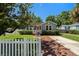 Quaint home featuring a charming front porch, well-kept lawn, and a classic white picket fence at 702 W Kentucky Ave, Tampa, FL 33603