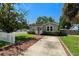 Charming cottage-style home with a well-manicured lawn, picket fence, and inviting front porch at 702 W Kentucky Ave, Tampa, FL 33603