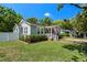 Charming bungalow with tidy lawn, brick pathway, and inviting front porch flying the US flag at 702 W Kentucky Ave, Tampa, FL 33603