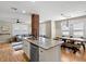 Open kitchen featuring a central island with granite counters, brick accent column, and stainless steel appliances at 702 W Kentucky Ave, Tampa, FL 33603
