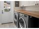Bright laundry room with modern washer and dryer, and a butcher block countertop at 702 W Kentucky Ave, Tampa, FL 33603