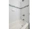 White tiled shower and tub with stylish blue tile border at 702 W Kentucky Ave, Tampa, FL 33603