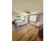 Bright bedroom featuring light wood floors, a ceiling fan, and an accent chair at 7314 Ivanhoe Dr, Port Richey, FL 34668