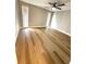 Bedroom features wood-look floors, ceiling fan, and natural light from windows at 7314 Ivanhoe Dr, Port Richey, FL 34668
