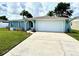 Quaint single-story home with a vibrant green lawn, appealing landscaping, and an attached two-car garage at 7314 Ivanhoe Dr, Port Richey, FL 34668