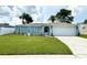 Attractive one-story home featuring a manicured front lawn, colorful landscaping, and an attached two-car garage at 7314 Ivanhoe Dr, Port Richey, FL 34668