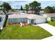 Charming one-story home featuring a well-manicured lawn, fresh landscaping, and attached two-car garage at 7314 Ivanhoe Dr, Port Richey, FL 34668